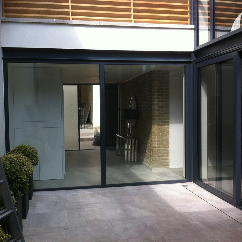 Floor-to-ceiling sliding doors opening to courtyard in Gerrards Cross