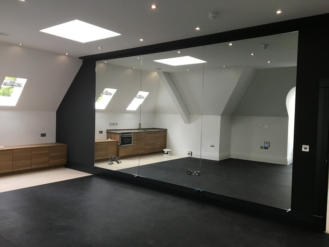 Frameless glass wall dividing loft conversion in Gerrards Cross